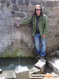 Me standing next to fountain in Cuzco Peru